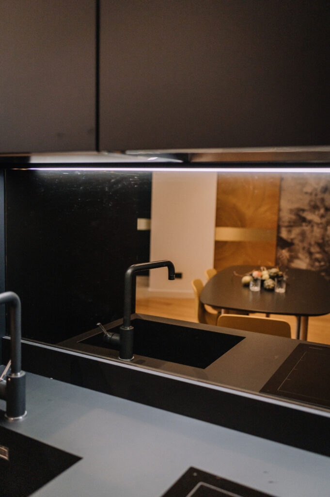 Dettagli della cucina scura, lavandino e piano cottura neri della residenza C